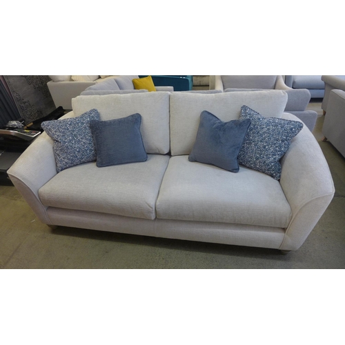 1523 - An ivory velvet three seater sofa with contrasting scatter cushions