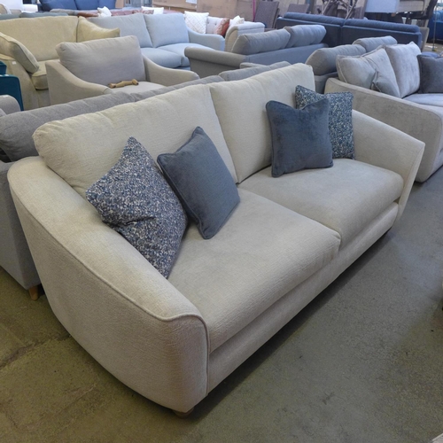 1523 - An ivory velvet three seater sofa with contrasting scatter cushions