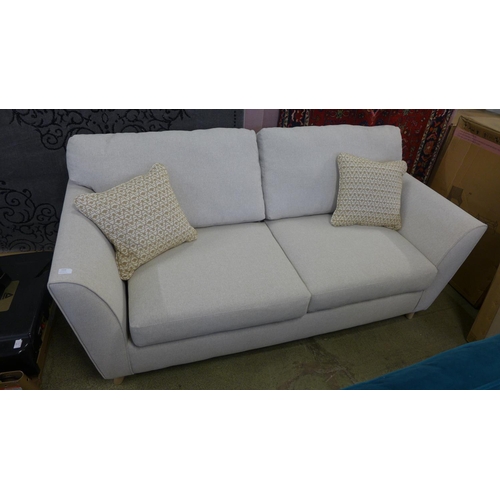 1525 - An oatmeal upholstered three seater sofa