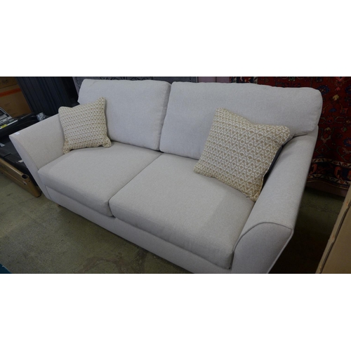 1525 - An oatmeal upholstered three seater sofa