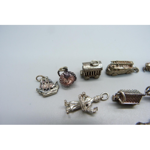 1000 - A collection of fifteen silver and white metal charms including fire engine, VW Beetle, lion, boat a... 