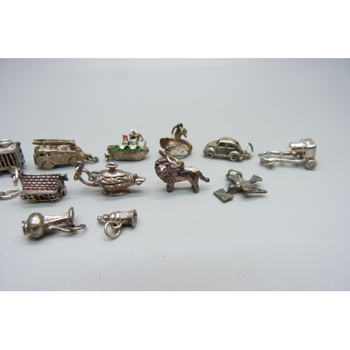 1000 - A collection of fifteen silver and white metal charms including fire engine, VW Beetle, lion, boat a... 