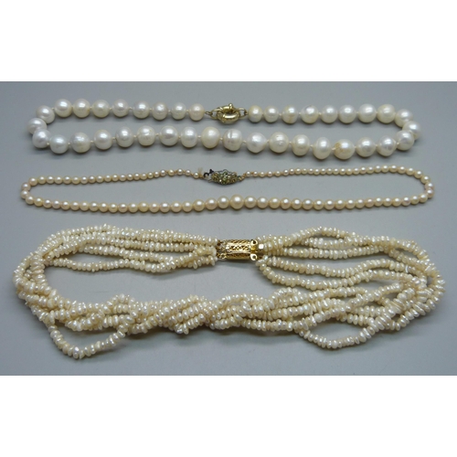 1051 - A string of cultured pearls and two strings of freshwater pearls, (one on a silver clasp)