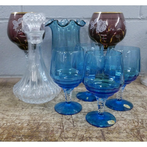 1058 - A collection of glassware including a decanter, four blue glasses, a blue vase and two taller colour... 