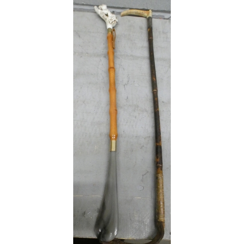 1064 - A figural handled shoe horn and a silver cuffed riding crop