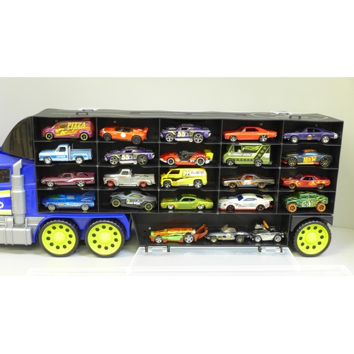 689 - A collection of Hot Wheels cars, housed in a Police lorry and another lorry containing model vehicle... 