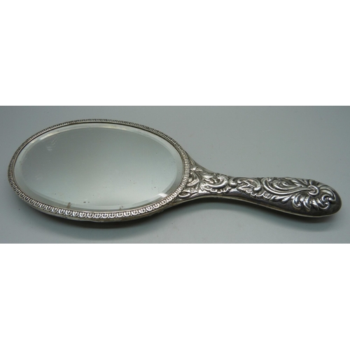 867 - A William Comyns embossed silver hand mirror, London 1900