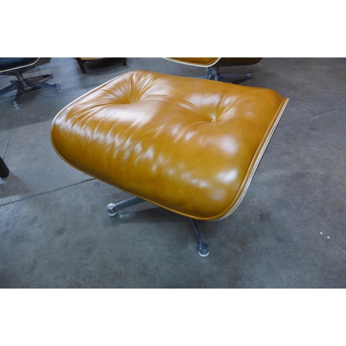 2 - A Charles & Ray Eames style simulated rosewood and tan leather revolving lounge chair and ottoman