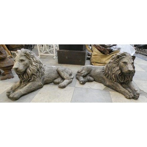 276 - A pair of concrete garden figures of recumbent lions