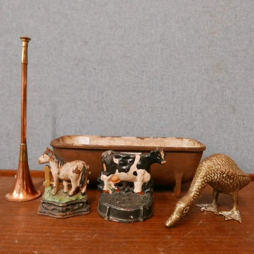 346 - A small cast iron feeder, two cast iron door cow shaped stops, brass duck and a small copper horn