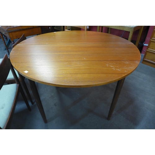 79 - A G-Plan teak extending dining table, a/f and seven teak dining chairs