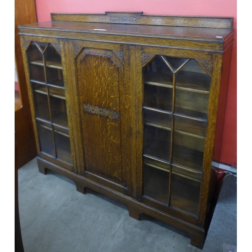 92 - An early 20th Century carved oak three door bookcase