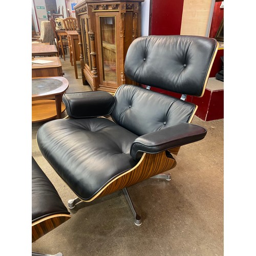 1 - A Charles & Ray Eames style simulated rosewood and black leather revolving lounge chair and ottoman