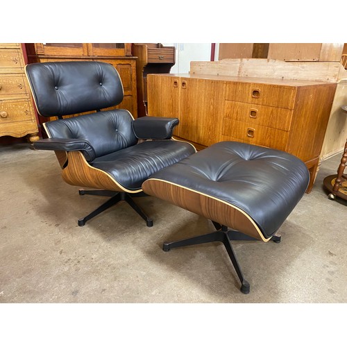 4 - A Charles & Ray Eames style simulated rosewood and black leather revolving lounge chair and ottoman