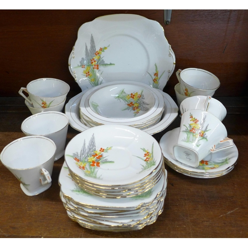 660 - An Art Deco tea service, eight cups and saucers, eleven side plates, a large plate and a matching fr... 