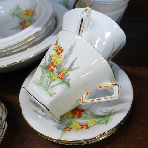 660 - An Art Deco tea service, eight cups and saucers, eleven side plates, a large plate and a matching fr... 