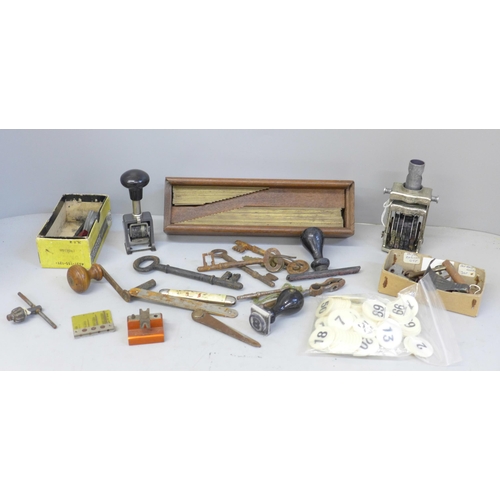 687 - Antique door keys, desk stamps, watch tools, etc., and a cased set of brass typesetting rules