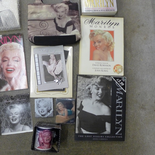 710 - A box of paperback books on Marilyn Monroe and other Marilyn Monroe items including a mug, calendars... 