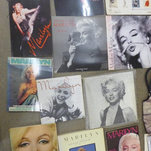 710 - A box of paperback books on Marilyn Monroe and other Marilyn Monroe items including a mug, calendars... 