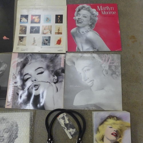 710 - A box of paperback books on Marilyn Monroe and other Marilyn Monroe items including a mug, calendars... 