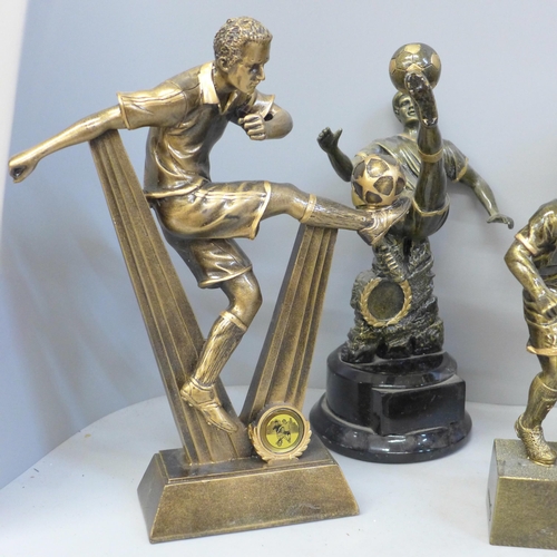 729 - Eight large football trophies including six footballers in action