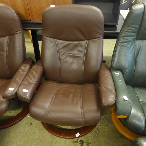 1597 - A brown leather reclining chair and footstool