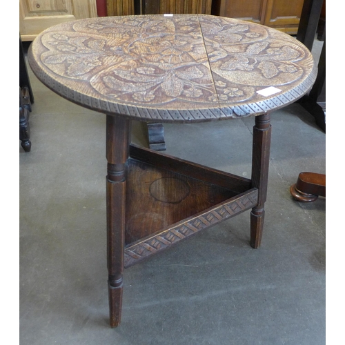 106 - An early 20th Century carved oak cricket table