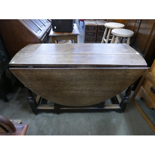 199 - A George III oak gateleg table and an oak linenfold panel bureau