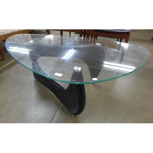 29 - An Isama Noguchi style black metal and glass topped coffee table