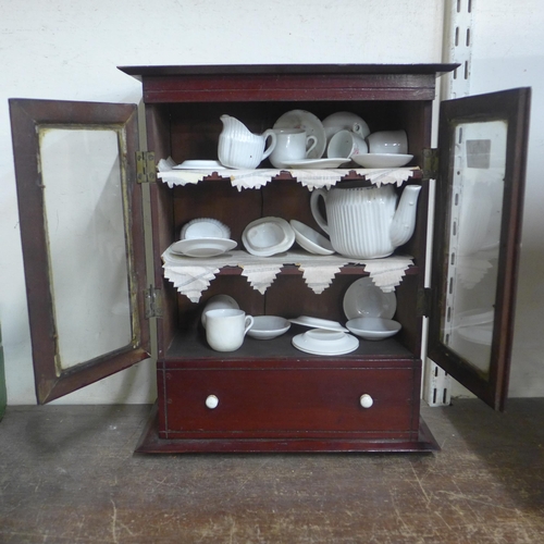 335 - A Victorian apprentices mahogany bookcase with miniature tea set