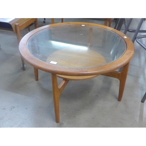 35 - A circular teak and glass topped coffee table