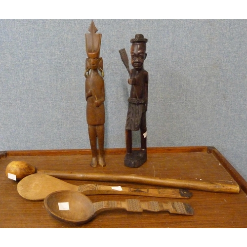 353 - A figure of an African man with paddle, a knobkerrie and two spoons