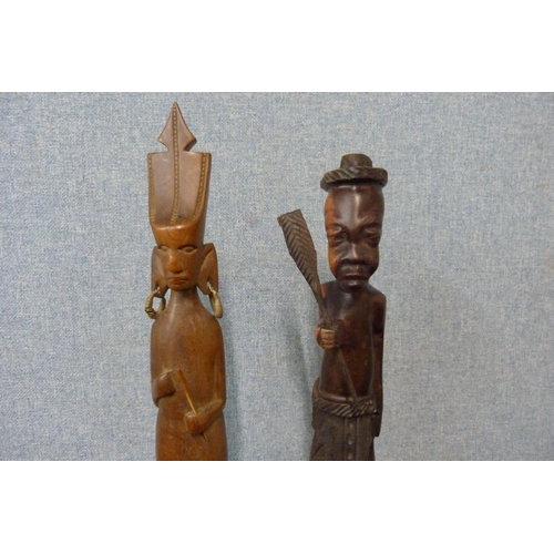 353 - A figure of an African man with paddle, a knobkerrie and two spoons