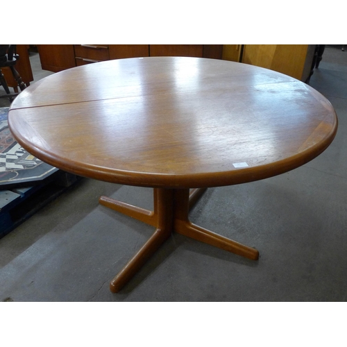 69 - A circular teak dining table