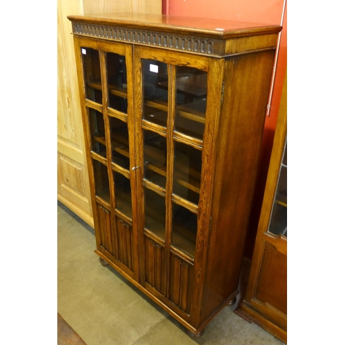 96 - A carved oak linenfold two door bookcase