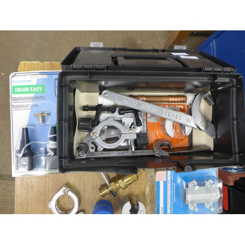 2032 - A small toolbox of plumbing tools including tap wrenches , pipe cutters, washer sets, tap tops etc