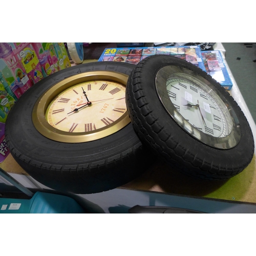 3112 - Two mixed sized tyre framed wall clocks