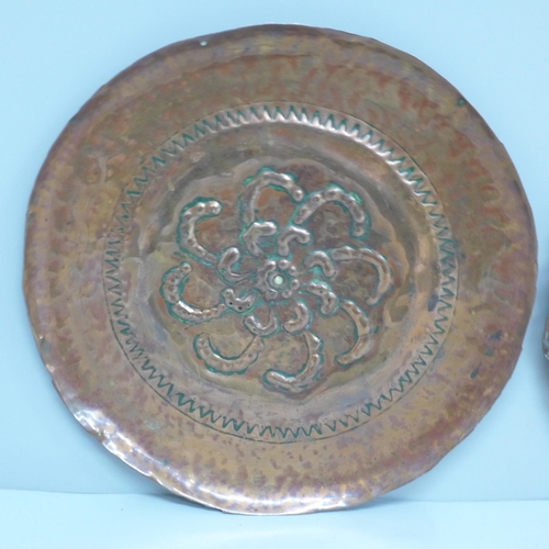 601 - Two embossed copper Arts and Crafts dishes, 22.5cm and 24.5cm