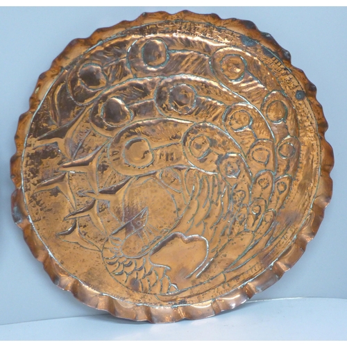 601 - Two embossed copper Arts and Crafts dishes, 22.5cm and 24.5cm