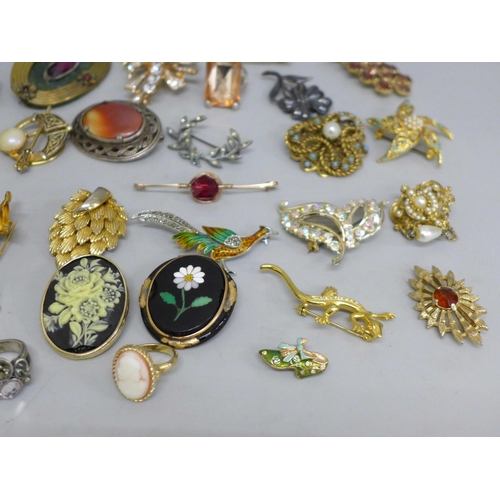 628 - A collection of vintage costume brooches, rings, etc., including some named examples, Miracle, Sphin... 