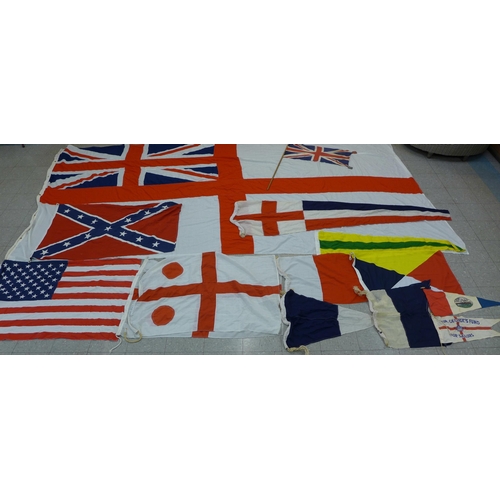 777 - A collection of flags; a large Navy white ensign flag, 4.6m x 2.1m, a Union Jack with broad arrow on... 