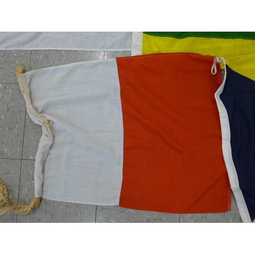 777 - A collection of flags; a large Navy white ensign flag, 4.6m x 2.1m, a Union Jack with broad arrow on... 