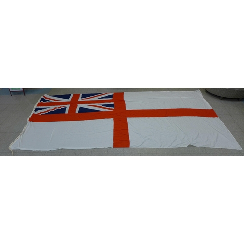 777 - A collection of flags; a large Navy white ensign flag, 4.6m x 2.1m, a Union Jack with broad arrow on... 