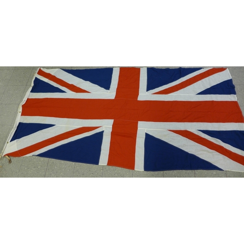 777 - A collection of flags; a large Navy white ensign flag, 4.6m x 2.1m, a Union Jack with broad arrow on... 