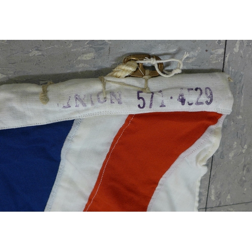 777 - A collection of flags; a large Navy white ensign flag, 4.6m x 2.1m, a Union Jack with broad arrow on... 