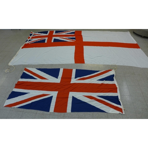 777 - A collection of flags; a large Navy white ensign flag, 4.6m x 2.1m, a Union Jack with broad arrow on... 