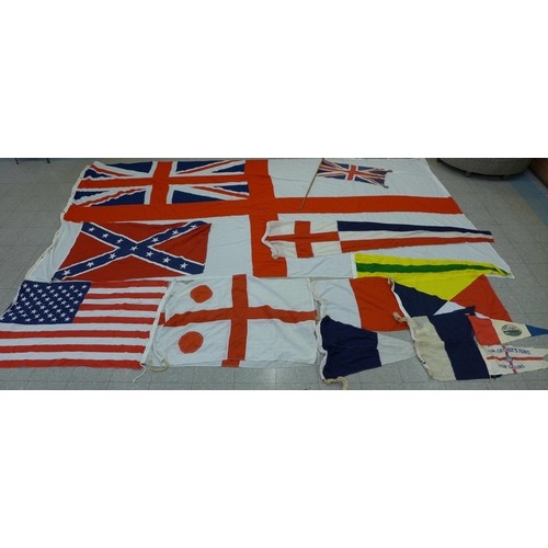 777 - A collection of flags; a large Navy white ensign flag, 4.6m x 2.1m, a Union Jack with broad arrow on... 