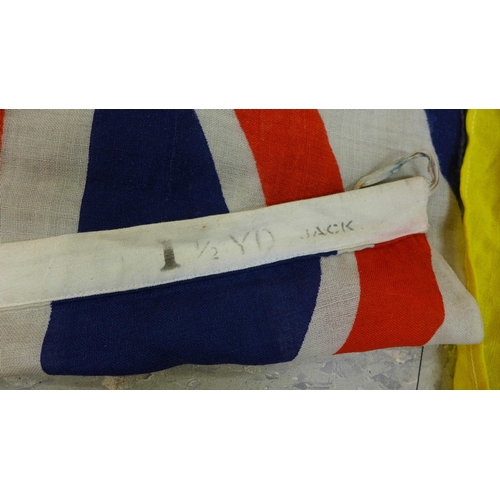 777 - A collection of flags; a large Navy white ensign flag, 4.6m x 2.1m, a Union Jack with broad arrow on... 