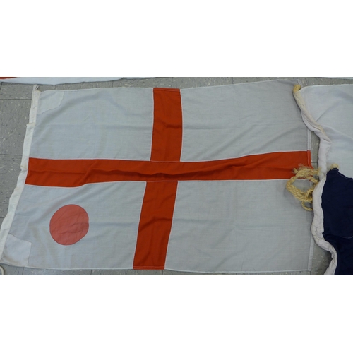 777 - A collection of flags; a large Navy white ensign flag, 4.6m x 2.1m, a Union Jack with broad arrow on... 