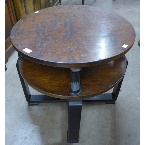 115 - An Art Deco walnut and ebonised circular coffee table, with carved dolphin supports